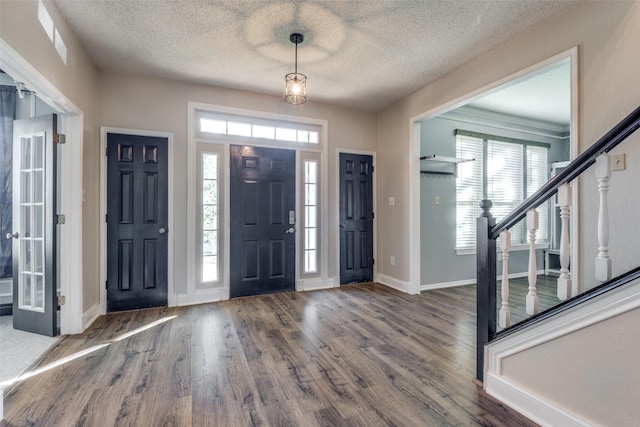 foyer entrance with hardwood / wood-style flooring and a textured ceiling