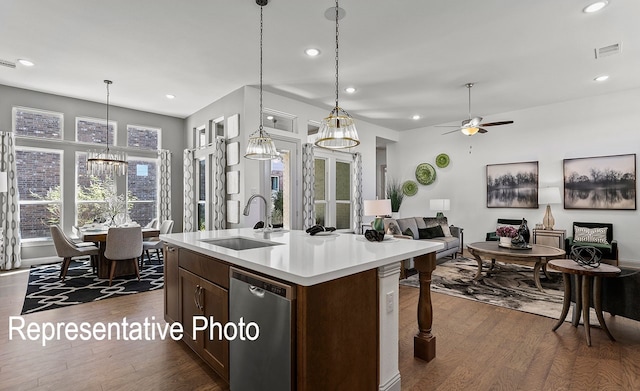 kitchen with dishwasher, dark hardwood / wood-style flooring, sink, and a center island with sink