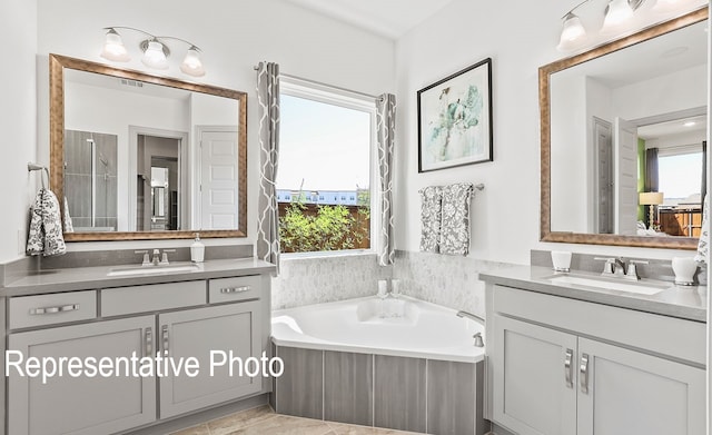 bathroom with tile patterned flooring, vanity, and a tub to relax in