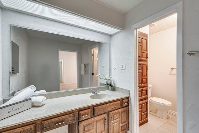 bathroom with tile patterned flooring, vanity, a textured ceiling, and toilet