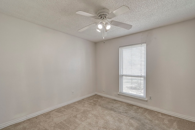 carpeted spare room featuring a textured ceiling and ceiling fan