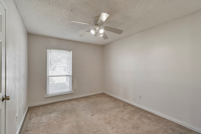 spare room with light carpet, ceiling fan, and a textured ceiling