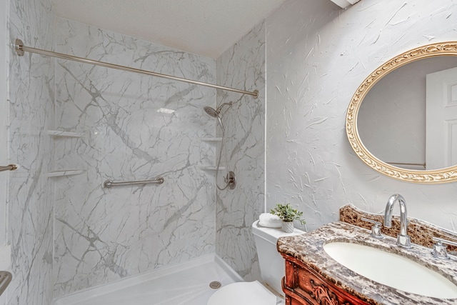 bathroom with vanity, toilet, and a tile shower