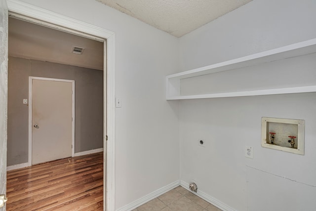 laundry area featuring washer hookup, hookup for an electric dryer, and a textured ceiling