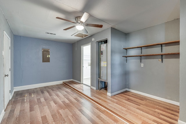 empty room featuring light wood-type flooring, electric panel, and ceiling fan