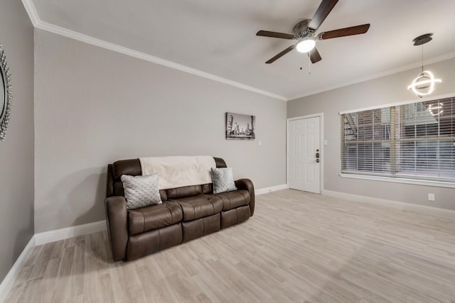 living room featuring ornamental molding, ceiling fan with notable chandelier, and light hardwood / wood-style flooring