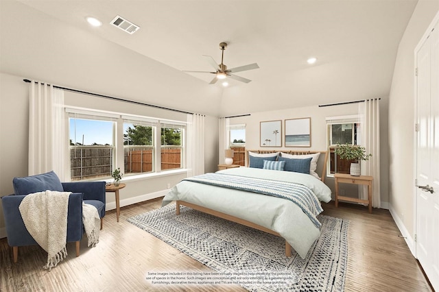 bedroom with visible vents, vaulted ceiling, baseboards, and wood finished floors