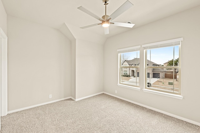 empty room featuring baseboards, vaulted ceiling, a ceiling fan, and carpet flooring