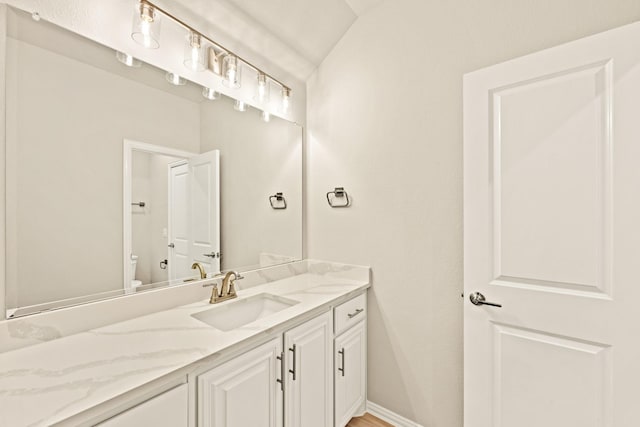 bathroom featuring vanity, toilet, and baseboards