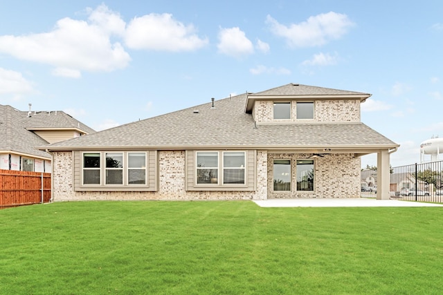 rear view of house featuring a fenced backyard, a shingled roof, and a lawn