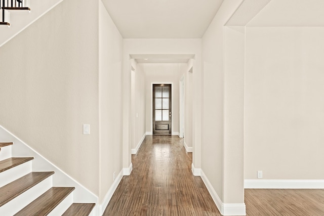 hallway featuring stairway, baseboards, and wood finished floors