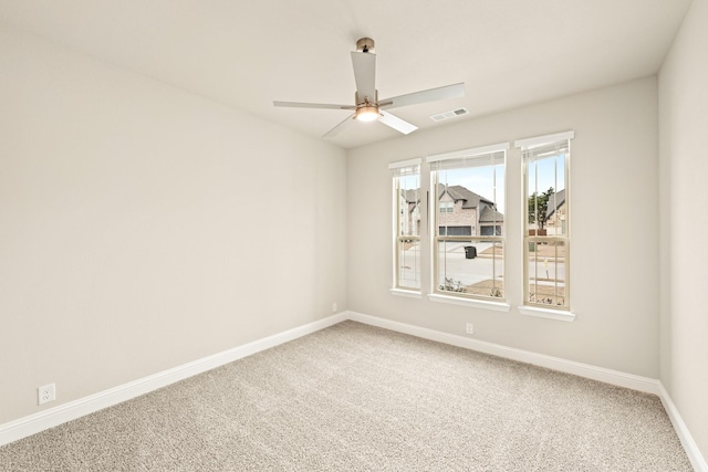 empty room with carpet, baseboards, visible vents, and a ceiling fan