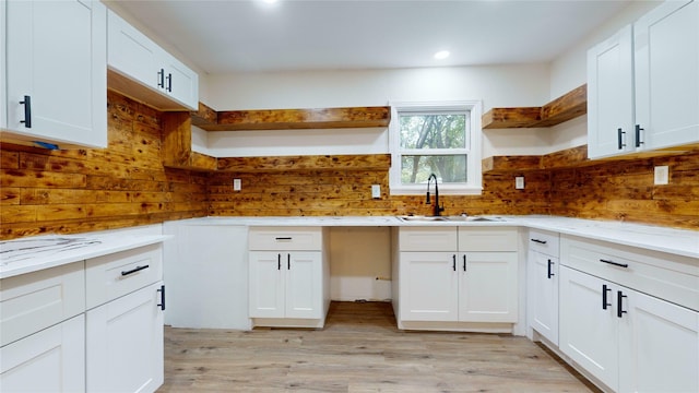 kitchen featuring white cabinetry, sink, and light hardwood / wood-style flooring