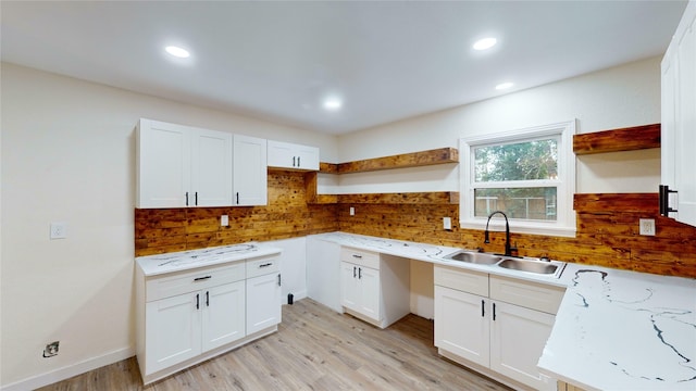 kitchen with sink, white cabinets, and light wood-type flooring