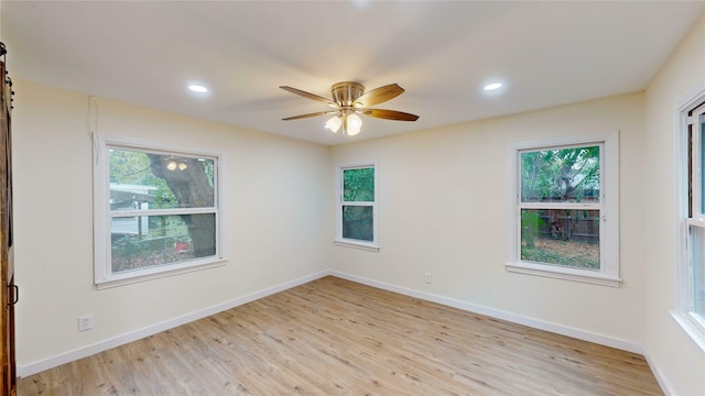 spare room featuring ceiling fan, plenty of natural light, and light hardwood / wood-style flooring