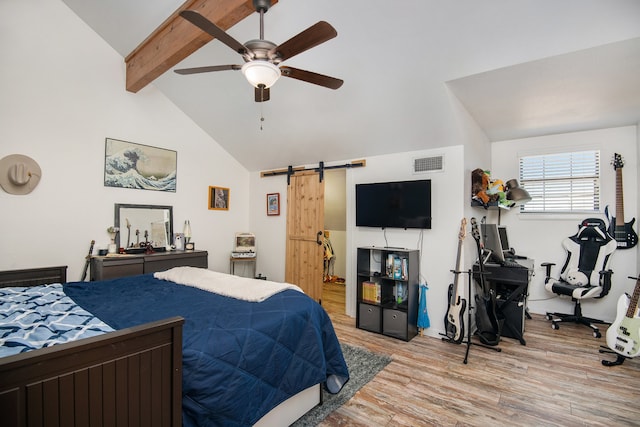 bedroom with ceiling fan, a barn door, light wood-type flooring, and lofted ceiling with beams