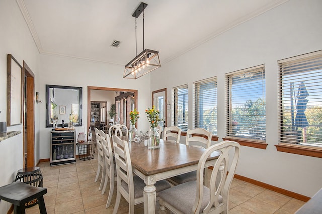 dining space featuring light tile patterned floors, ornamental molding, and a notable chandelier