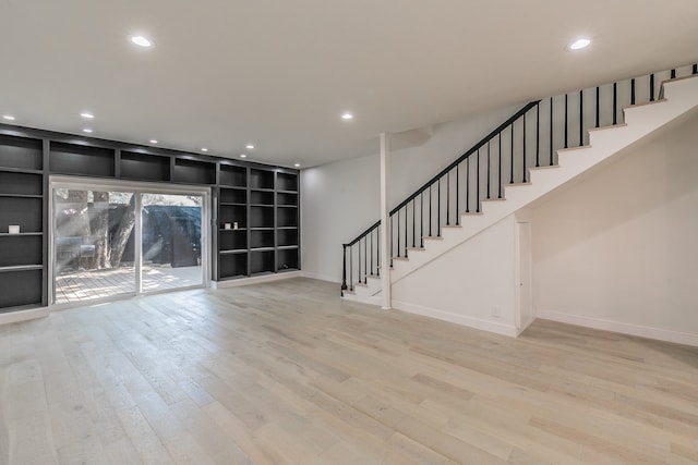 unfurnished living room with built in shelves and light hardwood / wood-style floors