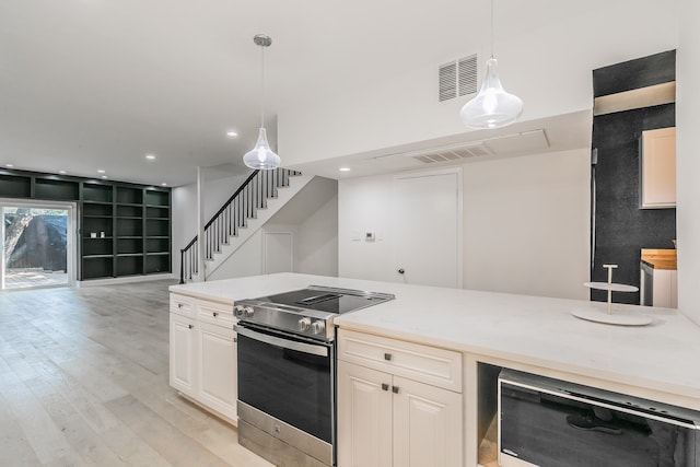 kitchen with pendant lighting, electric range, light hardwood / wood-style floors, and beverage cooler