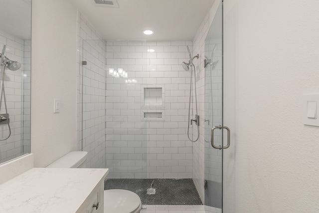 bathroom with walk in shower, vanity, and toilet