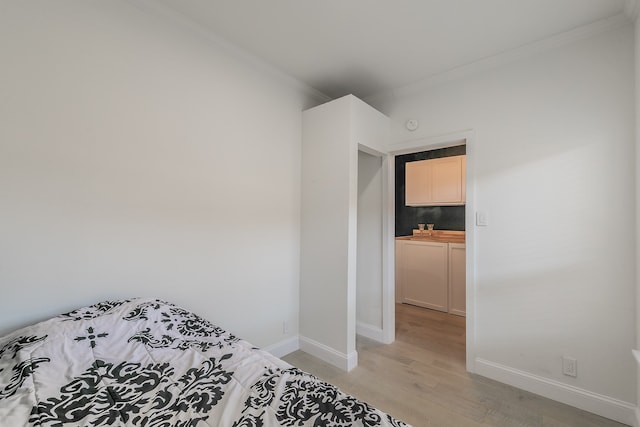 bedroom with light hardwood / wood-style flooring and ornamental molding