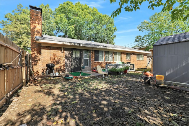 back of house featuring a shed and a patio area