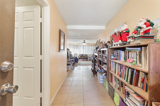 corridor with a textured ceiling and light tile patterned floors