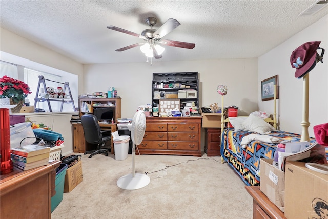 carpeted bedroom with ceiling fan and a textured ceiling