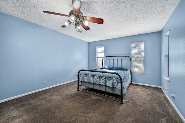 bedroom featuring ceiling fan, dark colored carpet, and a textured ceiling