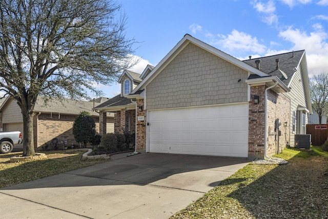 view of property exterior featuring brick siding, cooling unit, driveway, and a garage