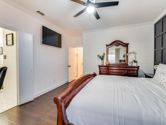 bedroom featuring ornamental molding, ensuite bathroom, dark hardwood / wood-style flooring, and ceiling fan