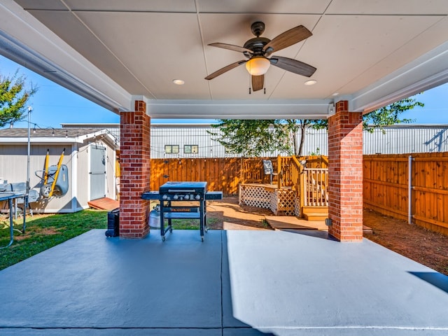 view of patio with ceiling fan and a shed