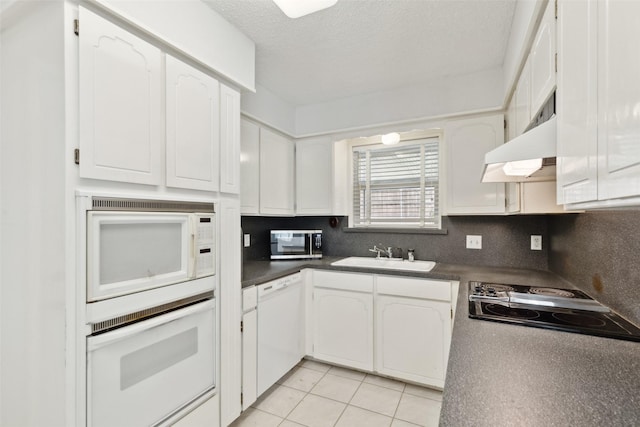 kitchen featuring light tile patterned floors, sink, white appliances, and white cabinets