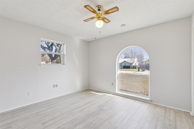 spare room featuring light hardwood / wood-style floors, a textured ceiling, and ceiling fan