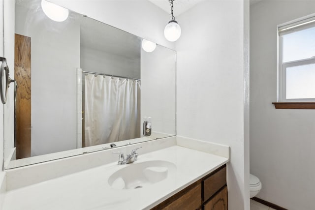 bathroom featuring toilet, walk in shower, and vanity