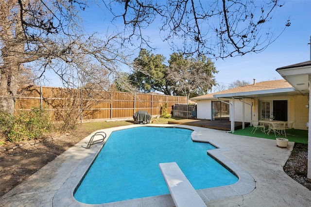 view of swimming pool with a diving board and a patio area