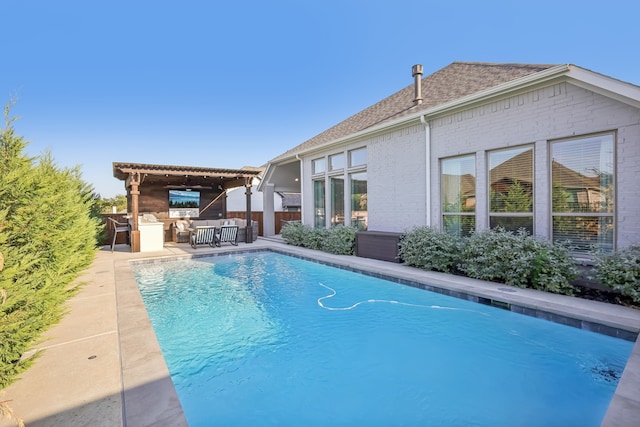 view of swimming pool featuring area for grilling, a patio area, and a bar