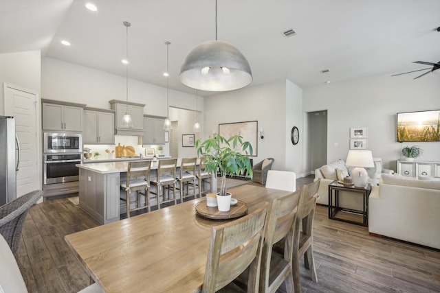 dining area featuring dark wood-type flooring, lofted ceiling, and ceiling fan