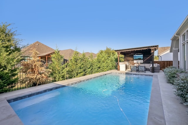 view of pool with exterior bar, a patio, and exterior kitchen