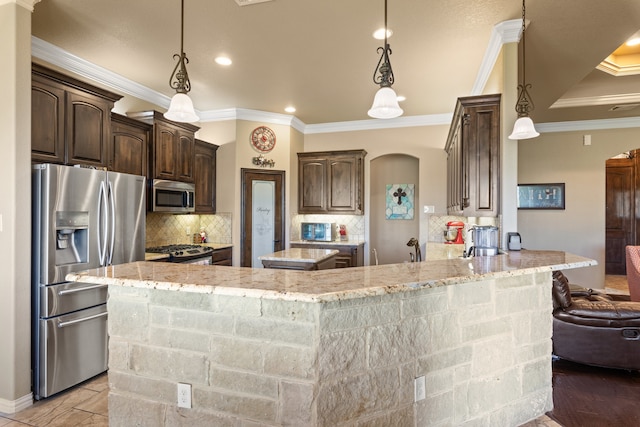 kitchen with crown molding, decorative light fixtures, and appliances with stainless steel finishes