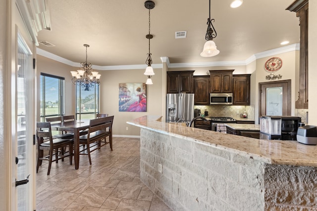 kitchen with light stone countertops, stainless steel appliances, decorative light fixtures, dark brown cabinets, and ornamental molding