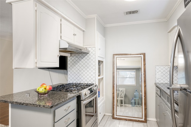 kitchen featuring stainless steel appliances, white cabinetry, exhaust hood, decorative backsplash, and dark stone countertops