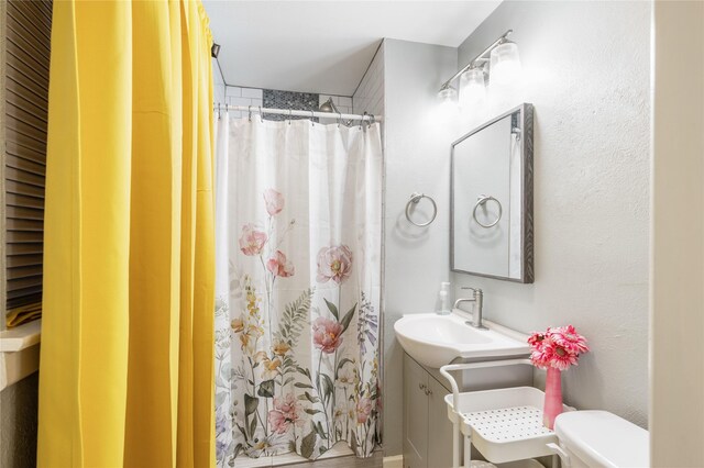 bathroom with curtained shower, vanity, and toilet