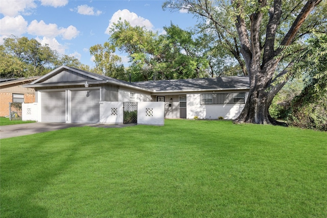 ranch-style home featuring a garage and a front lawn