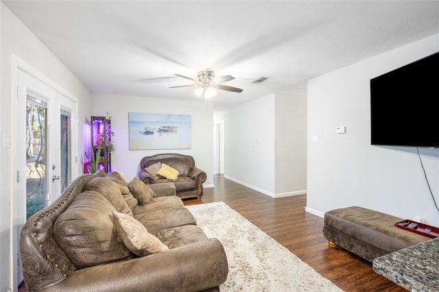 living room featuring dark hardwood / wood-style flooring and ceiling fan