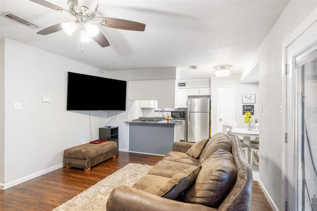 living room with dark wood-type flooring and ceiling fan