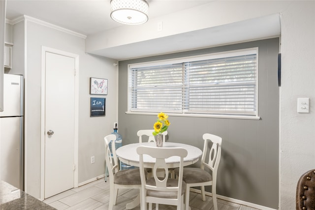 dining room with light hardwood / wood-style flooring and crown molding