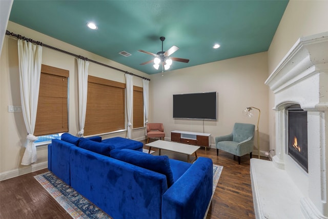 living room with ceiling fan, dark wood-type flooring, and a fireplace