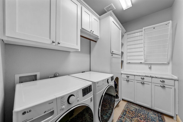 washroom with cabinets, light tile patterned floors, and separate washer and dryer