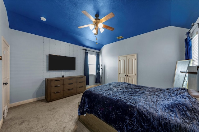 bedroom featuring ceiling fan, a closet, light colored carpet, and vaulted ceiling